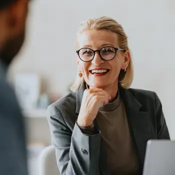 Businesswoman sat down smiling at a colleague