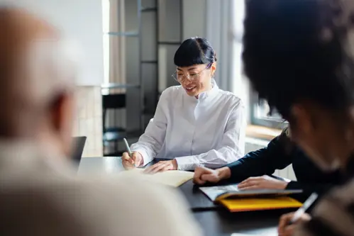 businesswoman taking notes during a meeting