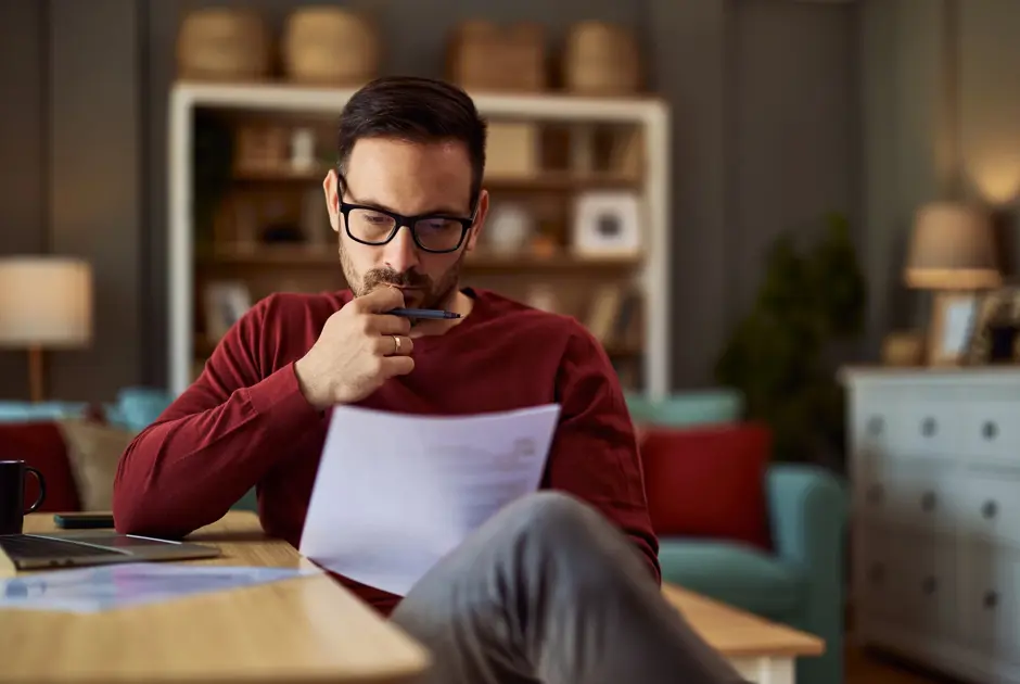 Male professional sat at a table reading a document
